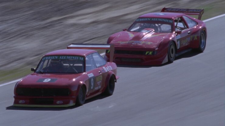 Two race cars enter a hard turn