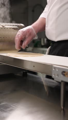 chef preparing dough on conveyor belt