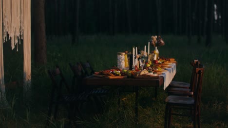 rustic outdoor dinner party in the forest at sunset