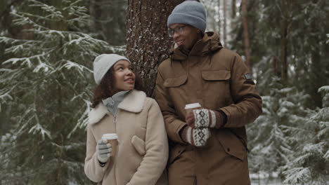 couple enjoying coffee in a snowy forest