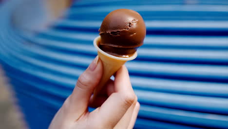 hand holding a chocolate ice cream cone