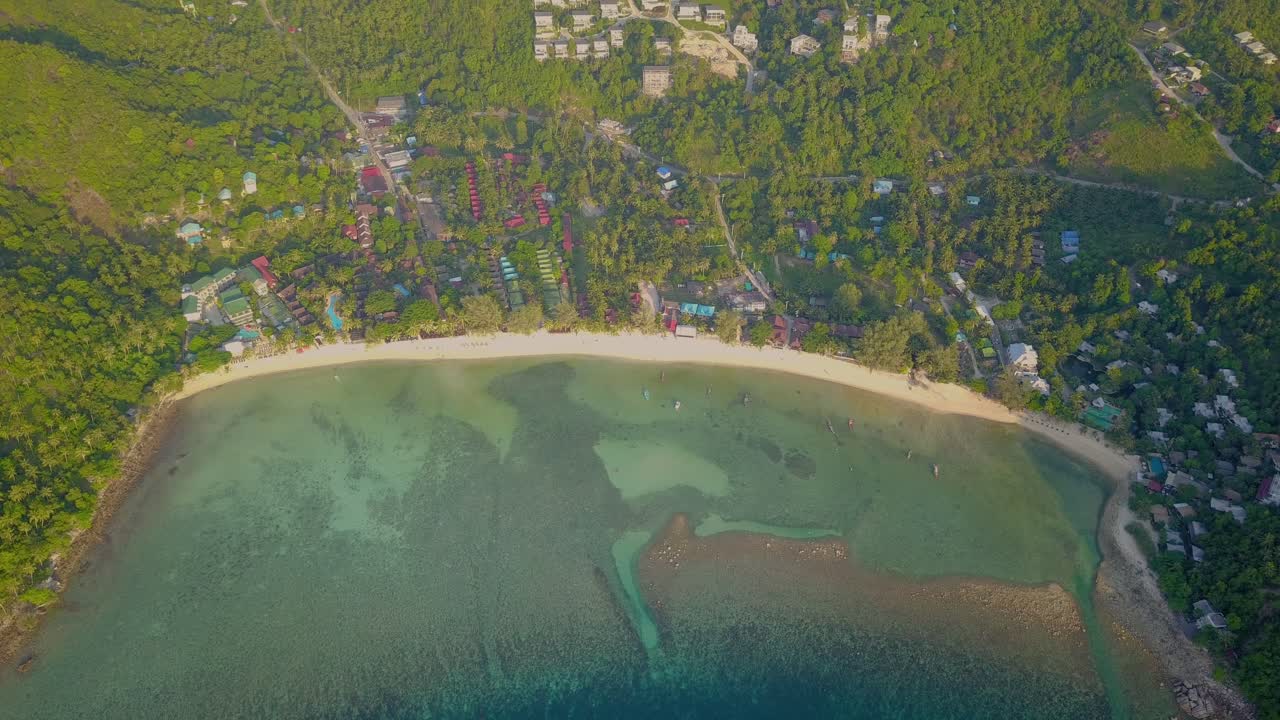 4k 공중 드론은 어선, 청록색 물, 산호 및 녹색 정글이 있는 태국 코팡안에 있는 샐러드 해변을 앞으로 밀어냅니다.