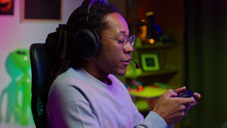 man playing video games with headphones and controller