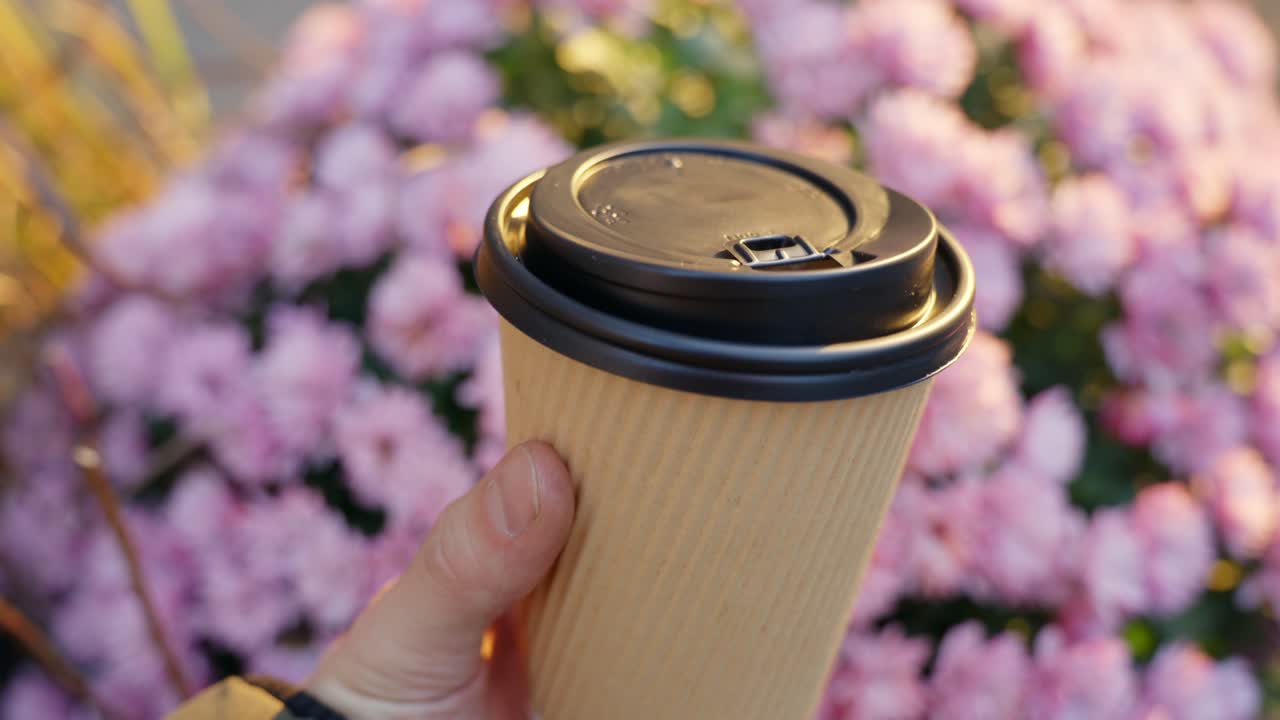 disfrutando del café de una taza reciclable en una mañana soleada en el parque