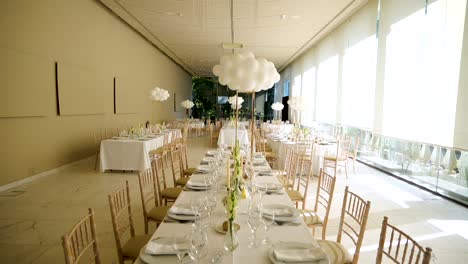 elegant white table setting for wedding or christening with balloons and fine tableware