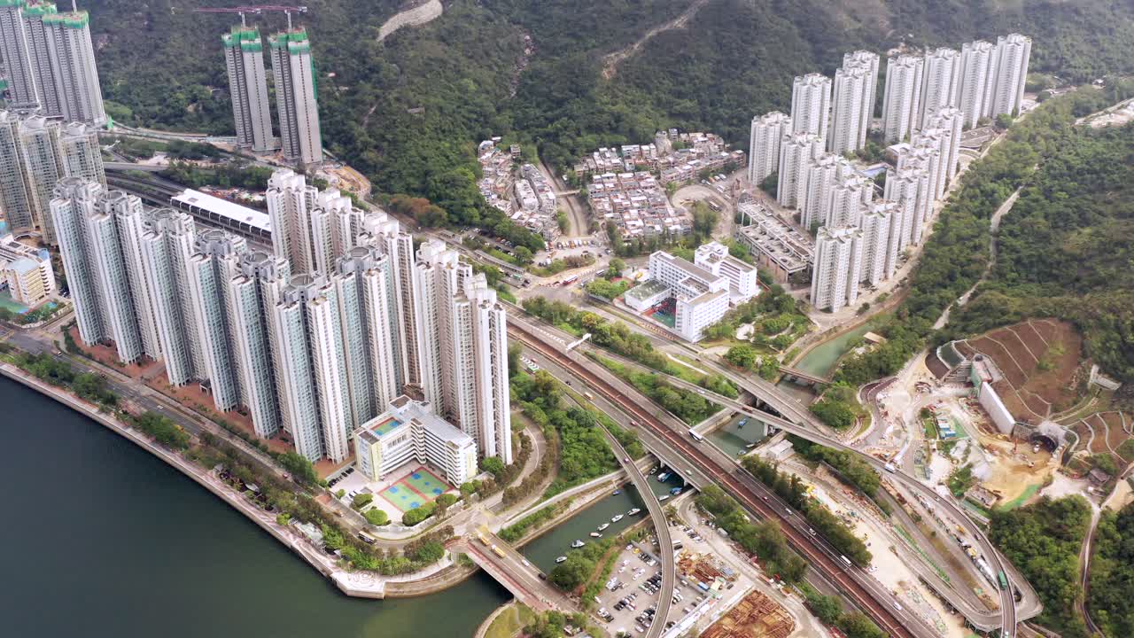 carreteras elevadas y transportes públicos que se cruzan entre los altos rascacielos blancos y las torres en construcción en tai shui hang en hongkong