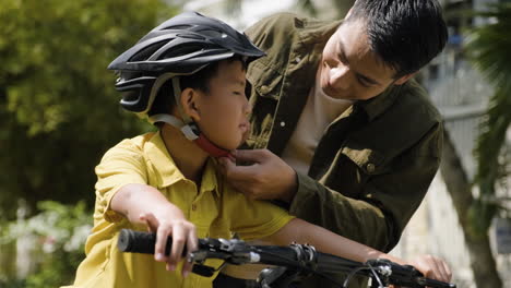 padre poniendo un casco a su hijo