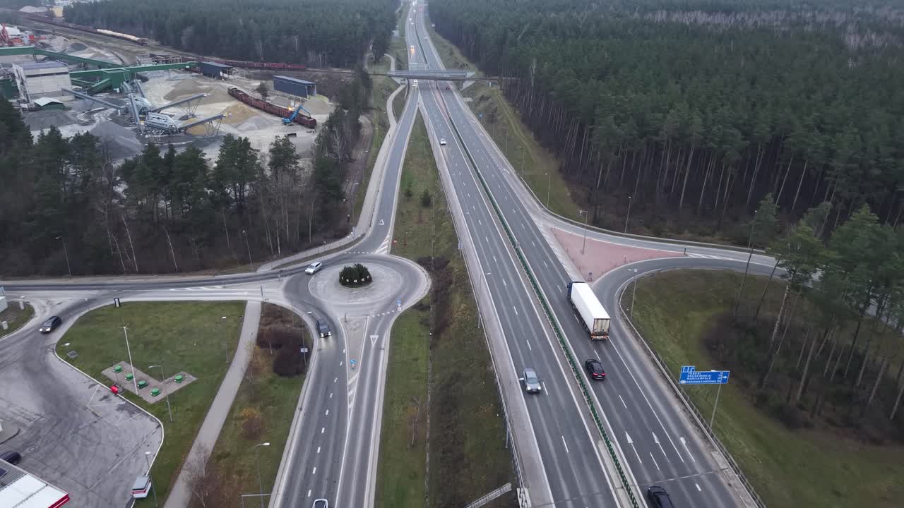 Endless highway and semi truck delivering cargo, aerial view