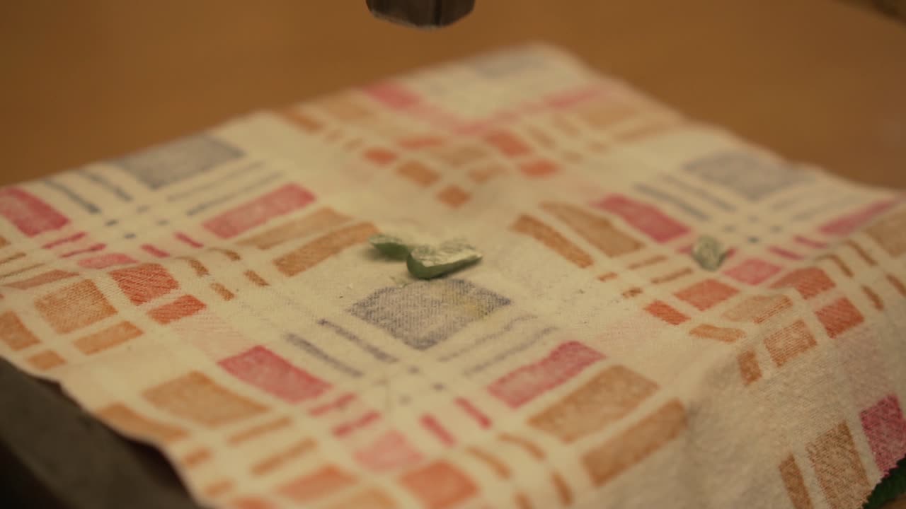 rompiendo piedra verde de nueva zelanda con un martillo en cámara lenta - primer plano