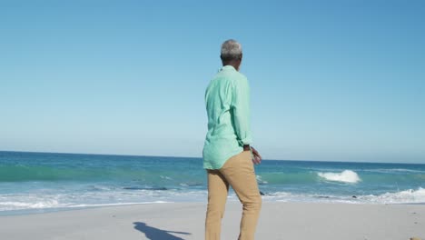 senior man walking besides the beach