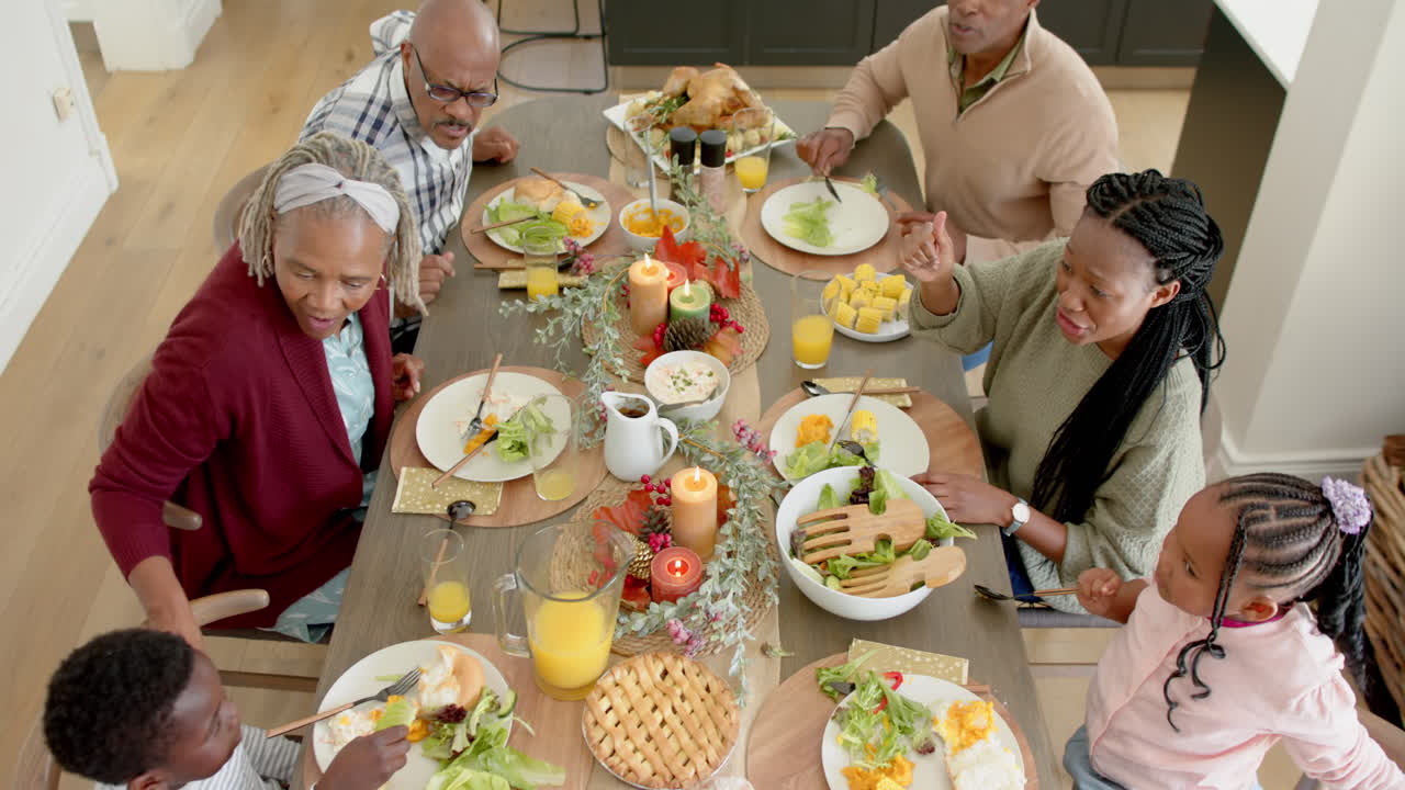 Afroamerikanske foreldre, barn og besteforeldre feirer Thanksgiving-middag, sakte film