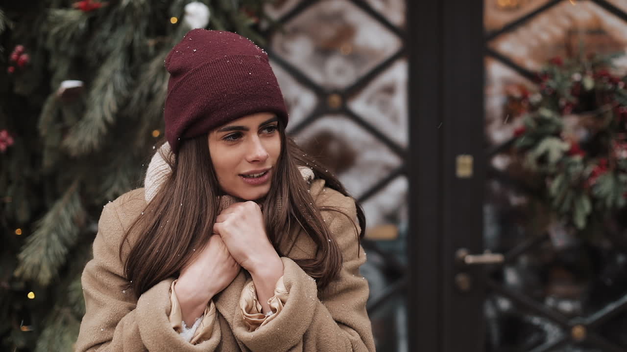 Woman in winter clothes near Christmas tree