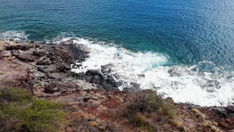 Flyover-the-shoreline-to-the-ocean-of-the-West-Mountains-in-Maui,-Hawaii