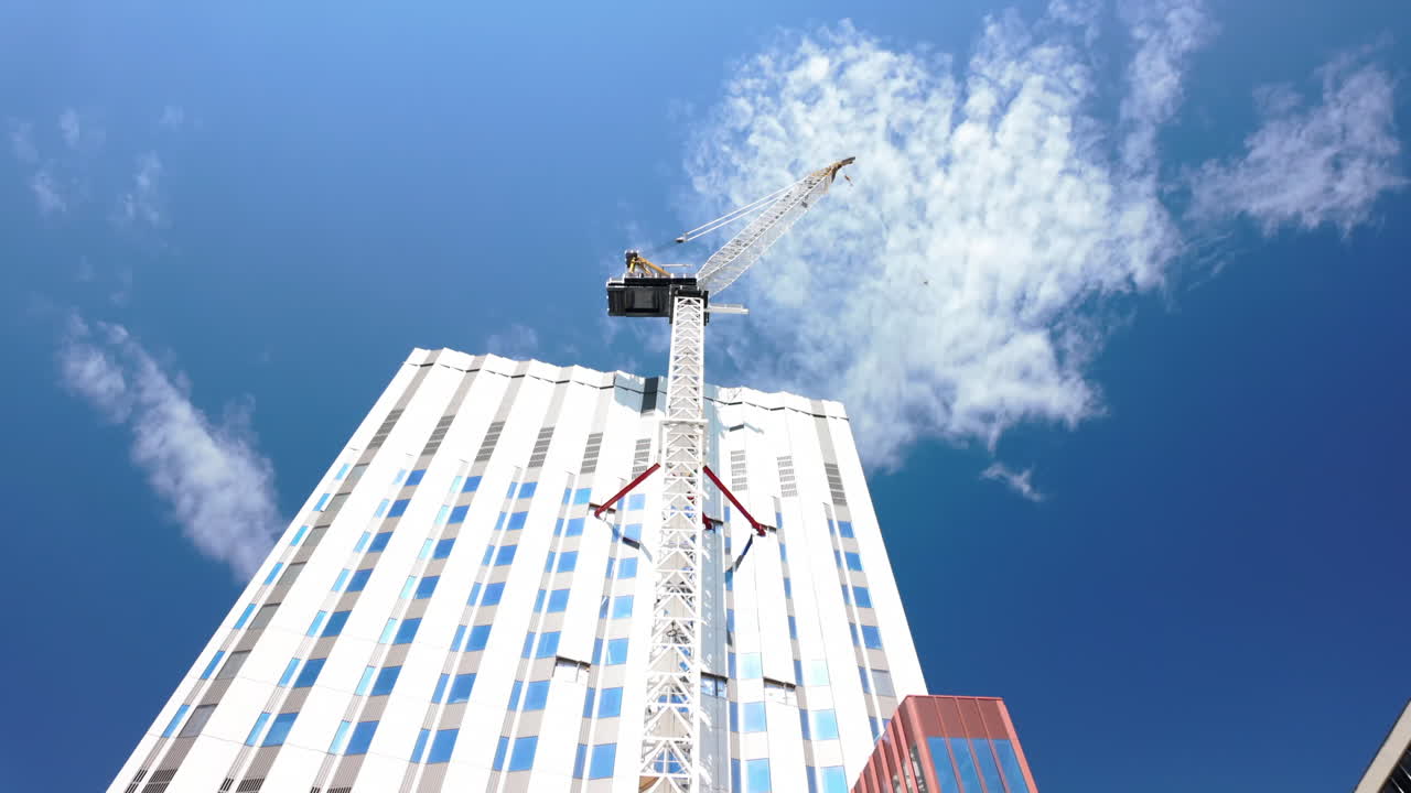 Crane on Boston building against sunny sky, construction technique focus