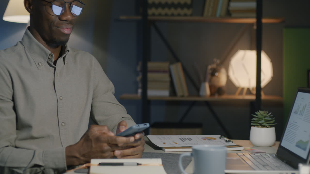Man working late in the office on smartphone