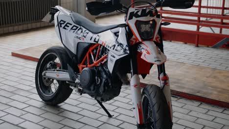 a panning and tilting parallax shot of a ktm supermoto in an industrial environment