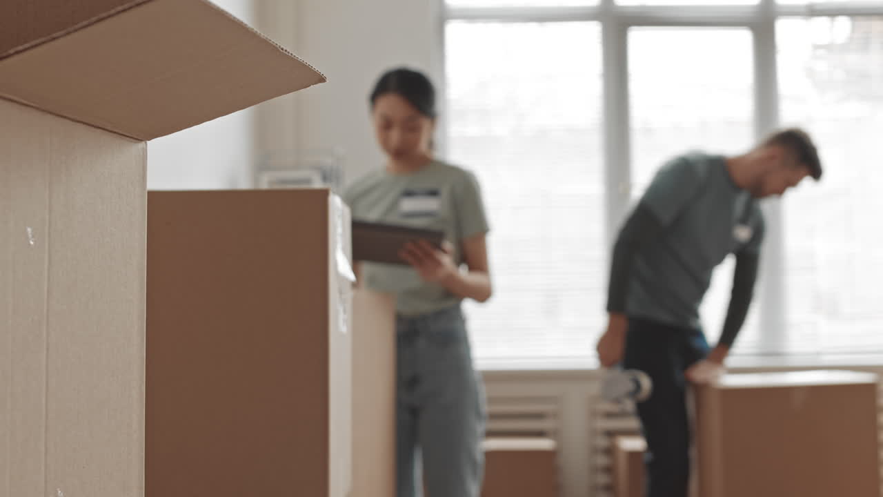 Couple moving into new home packing boxes