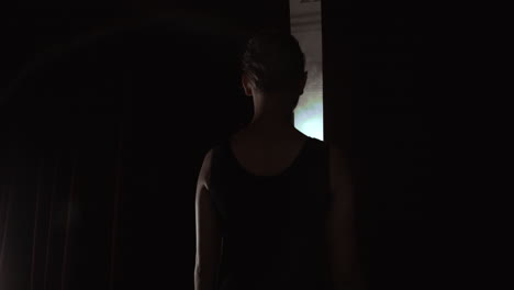 dancer standing behind a stage curtain waiting onstage and backstage fueled and prima ballet takes the stage for the beginning of the performance.