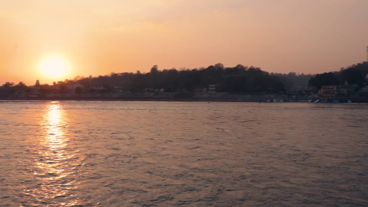 el cielo naranja de la puesta de sol sobre el horizonte fluvial del río al atardecer desde un video de ángulo plano se toma en rishikesh uttrakhand india el 15 de marzo de 2022