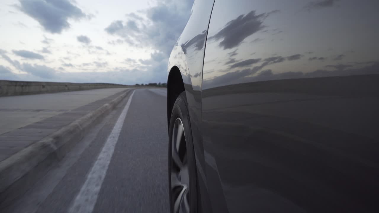 un coche conduciendo lentamente por la carretera antes del atardecer