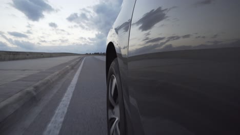 un coche conduciendo lentamente por la carretera antes del atardecer