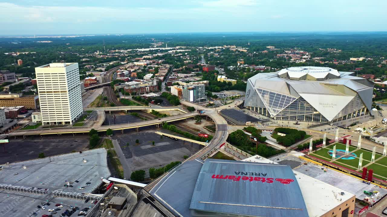 State Farm Arena, Mercedes Benz Stadium and Richard B. Russell Federal Building in Atlanta Downtown at sunrise. Aerial approaching wide shot. Georgia, USA. Traffic on highway intersection.