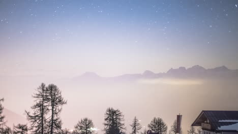 Estrellas-Moviéndose-Sobre-Las-Siluetas-De-Los-Alpes-Por-La-Noche-En-Una-Noche-Parcialmente-Nublada