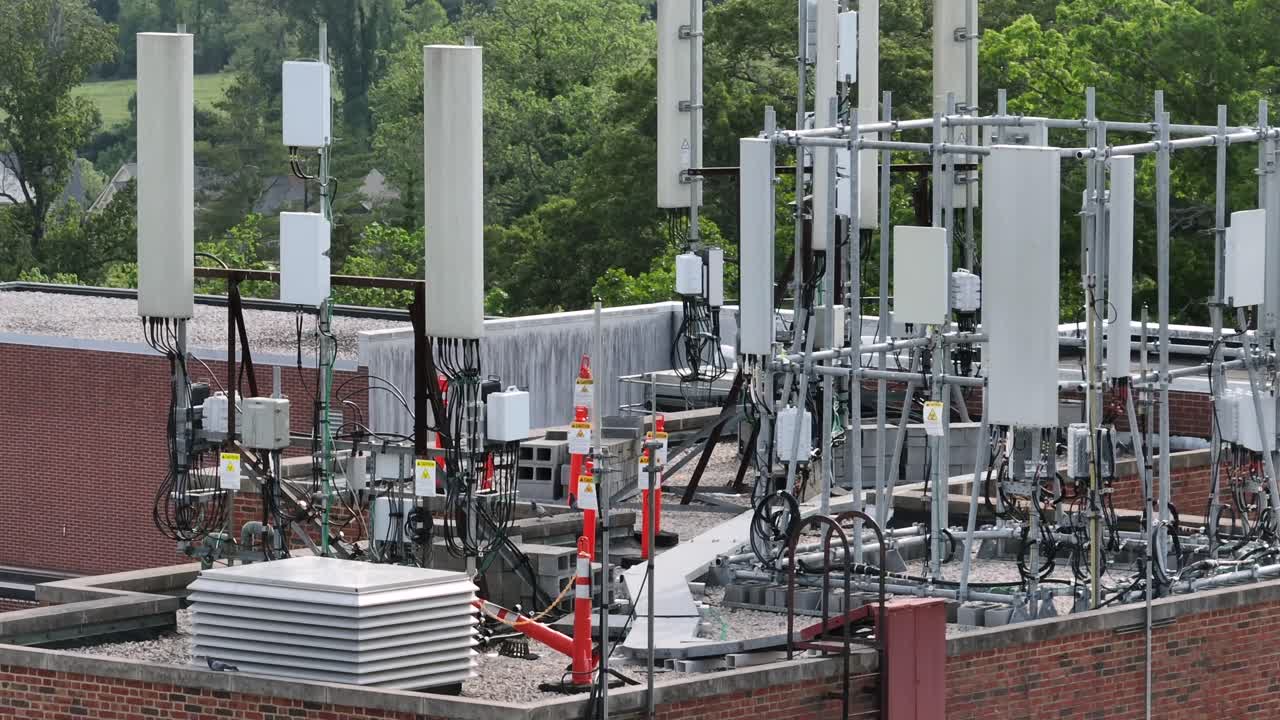 Rooftop equipped with various telecommunications equipment in America. Antennas and cables supporting mobile network infrastructure. Aerial view. Sunny day in USA.