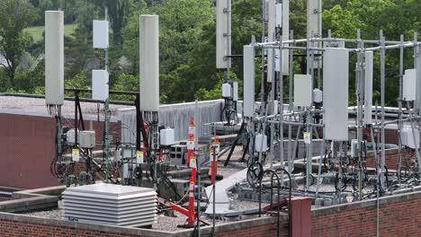 rooftop equipped with various telecommunications equipment in america. antennas and cables supporting mobile network infrastructure. aerial view. sunny day in usa.