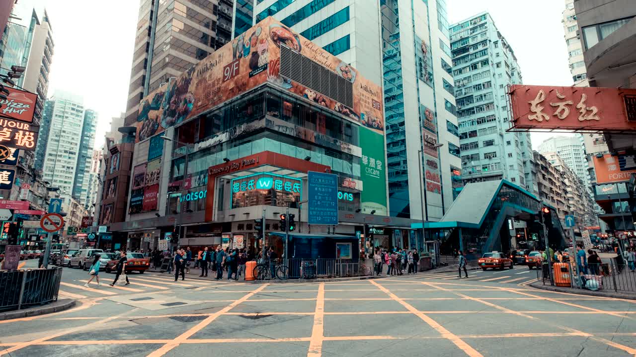 홍콩의 교통과 건물의 타임 스, 도로에서 달리는 차와 버스, 대도시의 비는 시간에 보행자 교차로에서 움직이는 사람들.