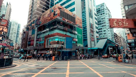 timelapse of traffic and building in hong kong. car and bus running on the road. people moving on pedestrian crosswalk on rush hour in the big city.