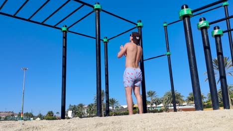 male doing pull ups, outdoor workout spot at a sunny beach, fit caucasian man doing bodyweight training calisthenics, shot in fuerteventura