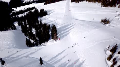 Aerial-view-of-ski-resort-with-people-snowboarding-down-the-hill