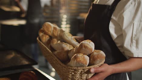 Animation-of-happy-asian-female-baker-holding-basket-with-baguettes