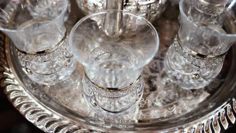 traditional moroccan tea glasses, adorned, on a silver tray in a bazaar in the medina of marrakesh (marrakech), morocco.