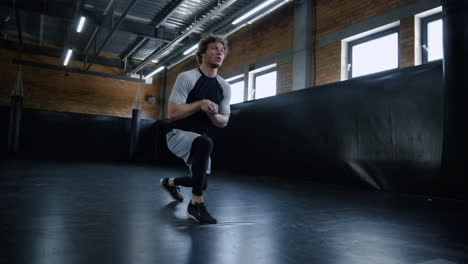 Young-kickboxer-doing-lunges-at-gym.-Sportsman-making-exercises-in-sport-club