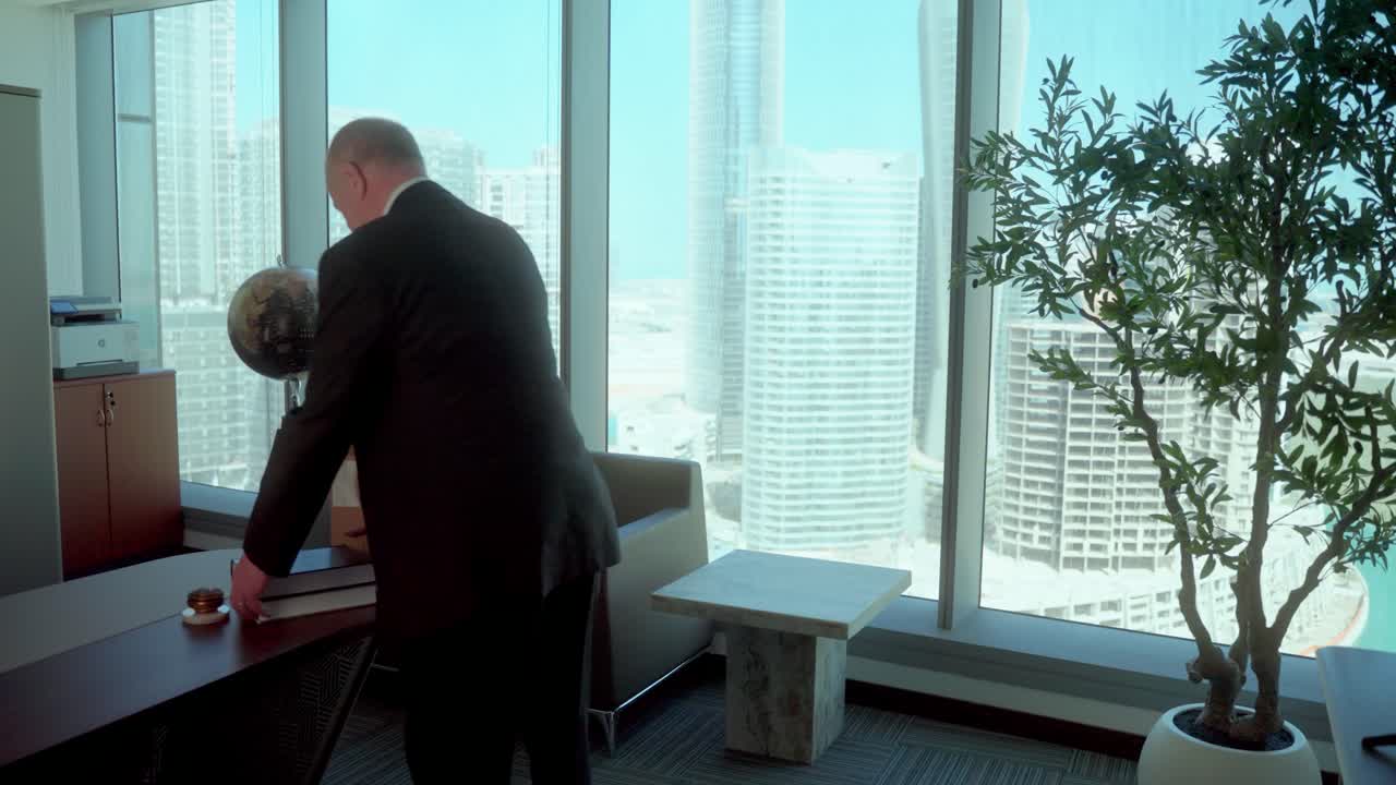 Senior man on the last day of work before retiring, packs up a box and leaves his dream office with sadness and nostalgia