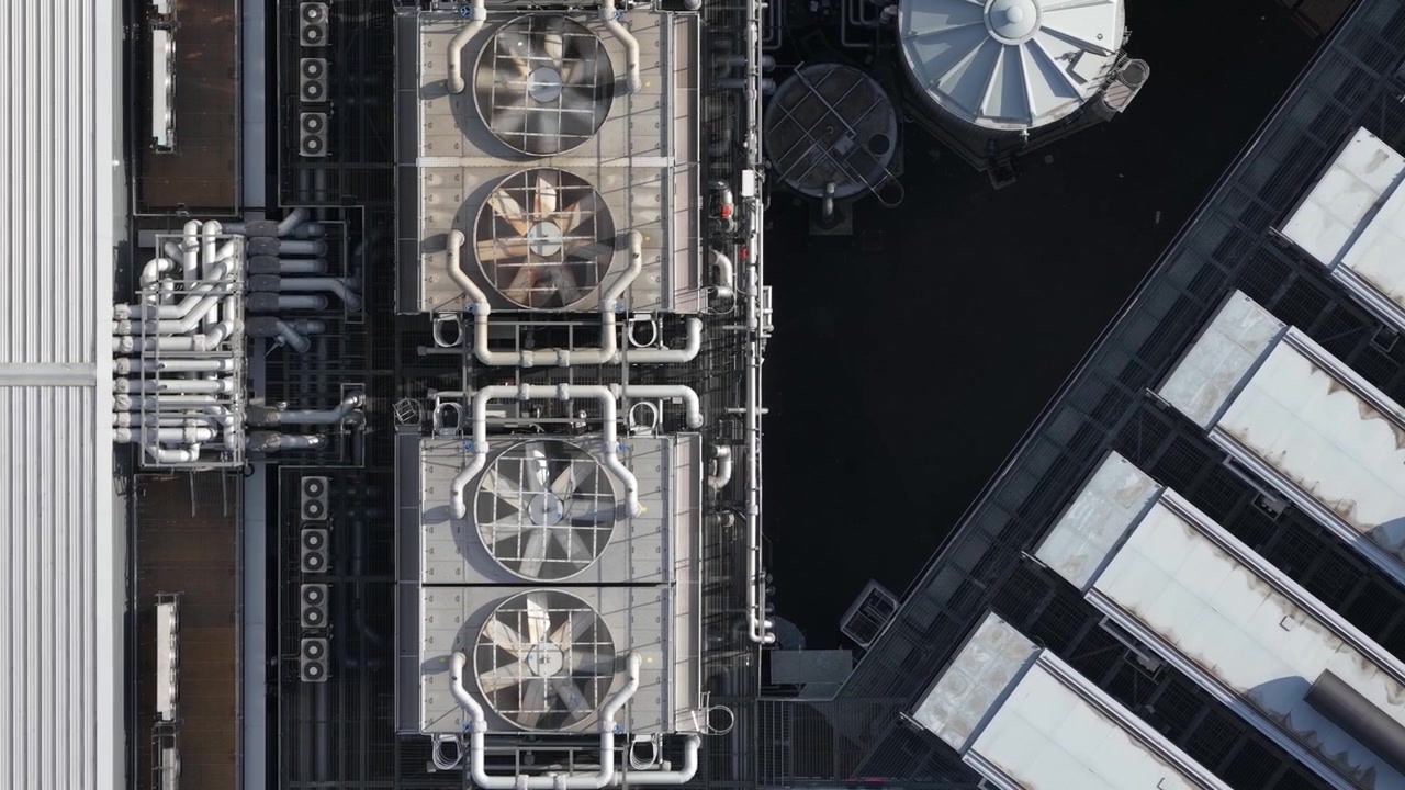 Top down aerial view of industrial cooling fans on a datacenter roof, illustrating concepts like big data, cloud computing, colocation, and machine learning infrastructure power consumption