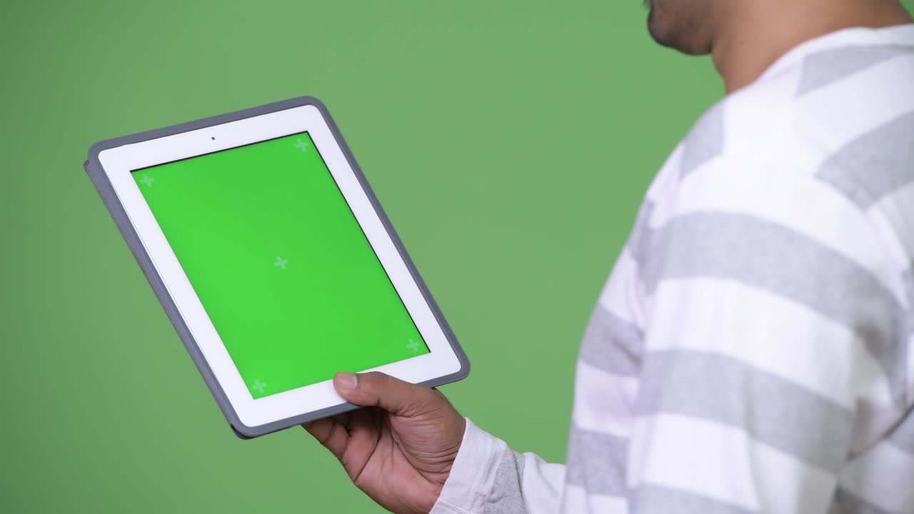 joven persa guapo mostrando la tableta digital