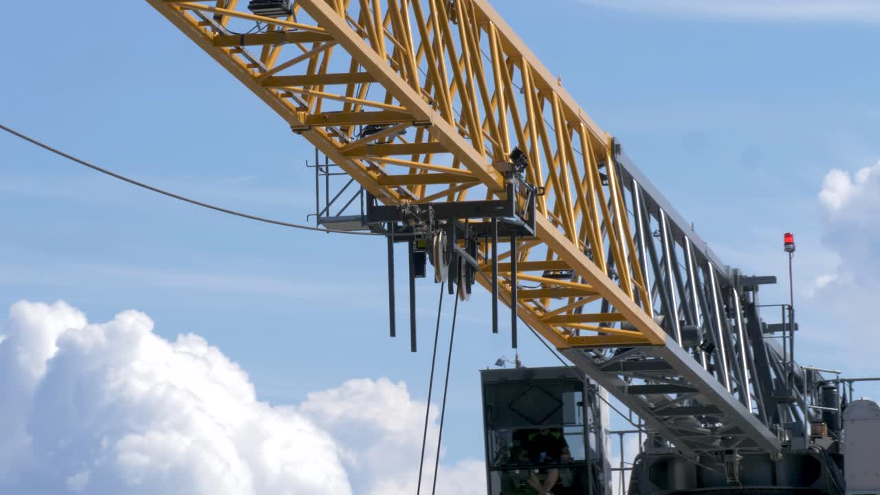 아름다운 구름으로 둘러싸인 노란색 건설 타워 크레인 스윙