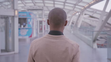 hombre afroamericano caminando en un edificio de oficinas