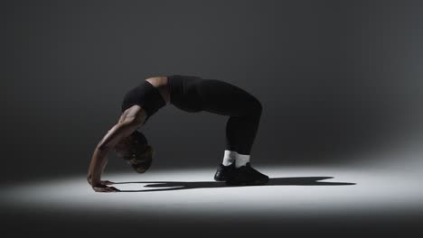 full length studio shot of woman wearing gym fitness clothing doing stretching exercise