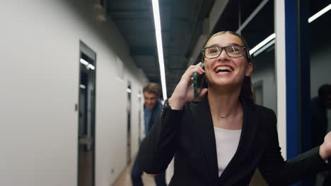 joyful partners celebrate successful share news on call. happy man throw papers