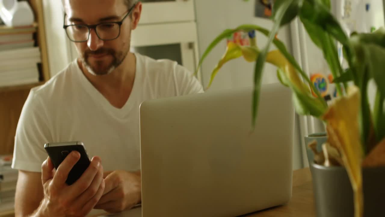 hombre usando teléfono móvil en la cocina 4k