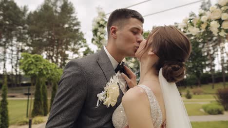 Newlyweds,-caucasian-groom-with-bride-walking,-embracing,-hugs-in-park,-wedding-couple