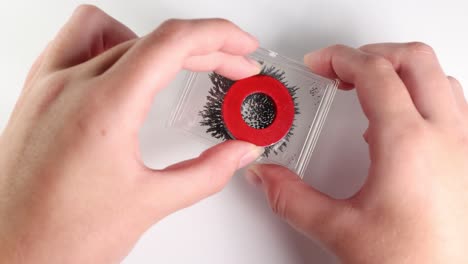 hands manipulate magnets over iron filings, demonstrating magnetic attraction and repulsion in a clear, well-lit setting