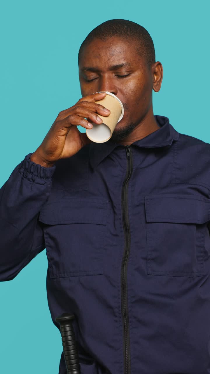 Tired African American Man Yawns and Drinks Coffee