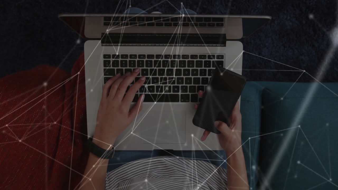 Woman typing on laptop and holding smartphone on sofa, displaying tech network lines with nodes