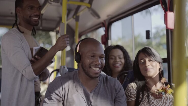 Diverse group of people smiling and listening to music on a bus