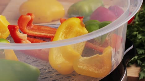 mixed vegetables, carrots, broccoli, and cauliflower in a food double boiler steamer basket in a stainless steel pot, healthy diet cooking method preserving minerals, vitamins and flavor